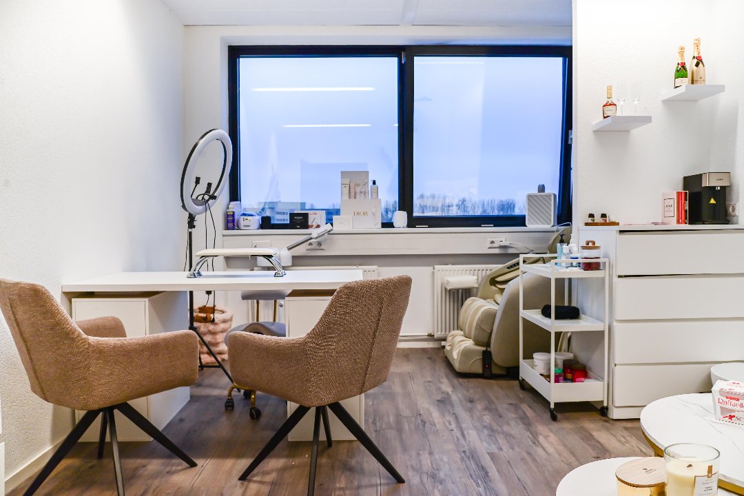 De studio van Maison Delux met nageltafel, twee fauteuils en de massagestoel bij het raam