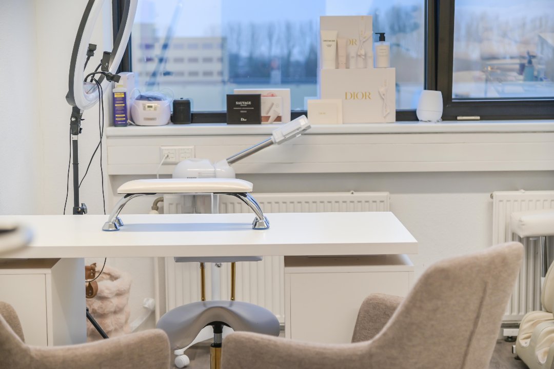 De nageltafel met handsteun en ringlamp, Dior-dozen op de vensterbank