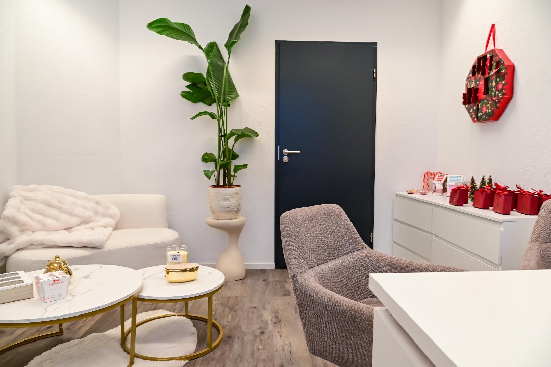 Loungehoek met bank, plaid en marmeren salontafels met gouden poten